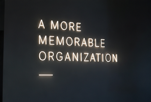 A lit sign on a dark wall: A more memorable organization.